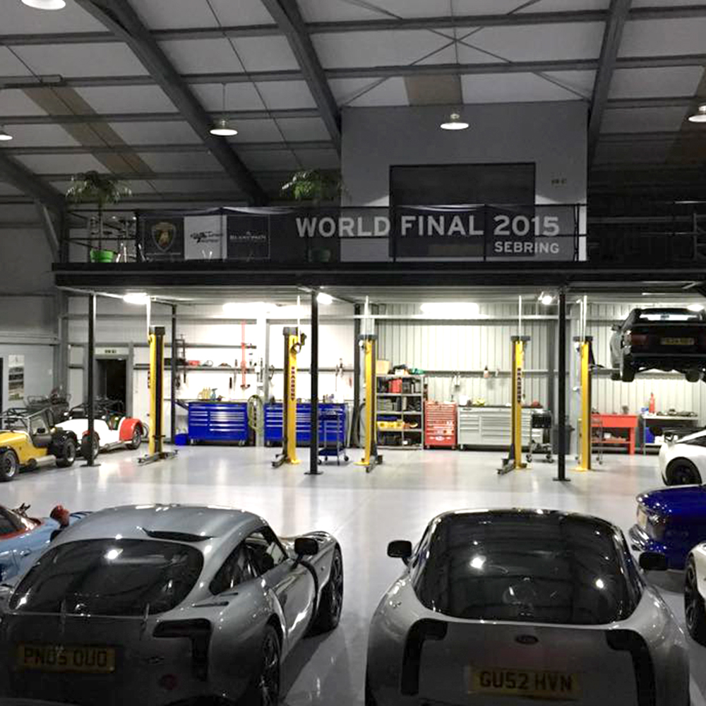overview of topcats racing large workshop housing performance cars tvr sagaris and tvr 350 in the foreground and balcony viewing area in the background